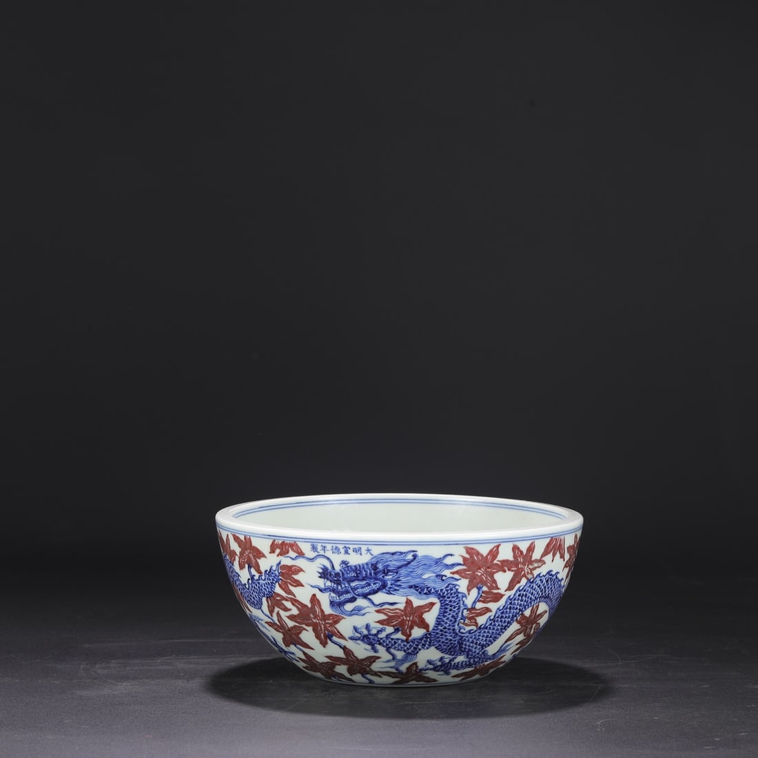 A large bowl washed with blue and white glaze red flowers and dragon patterns made in the Xuande era: The blue and white glaze made in the Xuande year of the Ming Dynasty is washed with red flower dragon pattern Size:H:12cm Calibre:27cm (The Dimensions Of All Batches Are Manually Measured.If You Need