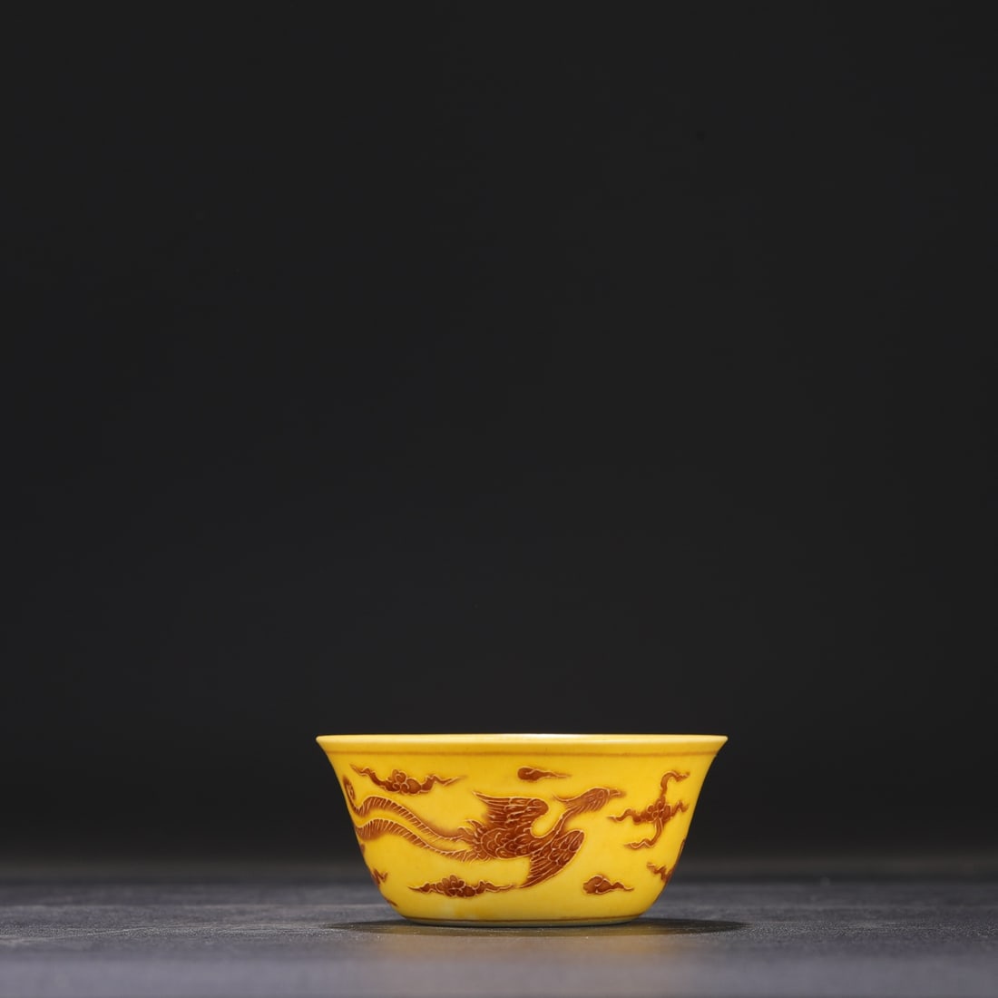 A yellow brown colored cloud phoenix pattern cup made in the Chenghua year of the Ming Dynasty: The yellow brown colorful cloud phoenix pattern cup made in the Chenghua year of the Ming Dynasty Size:H:4cm Calibre:8.5cm (The Dimensions Of All Batches Are Manually Measured.If You Need More Detaile
