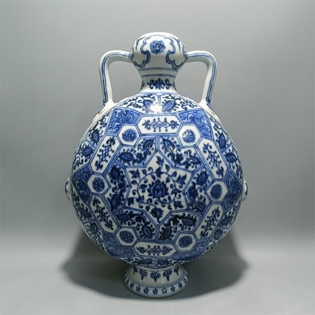 A flat bottle with a blue and white entwined floral pattern made in the Yongle year of the Ming: The blue and white entwined floral pattern flat bottle made in the Yongle year of the Ming Dynasty Size:H:18cmBellydiameter:21.5cmCalibre:3.5cmBottom:7.5cm (The Dimensions Of All Batches Are Manually