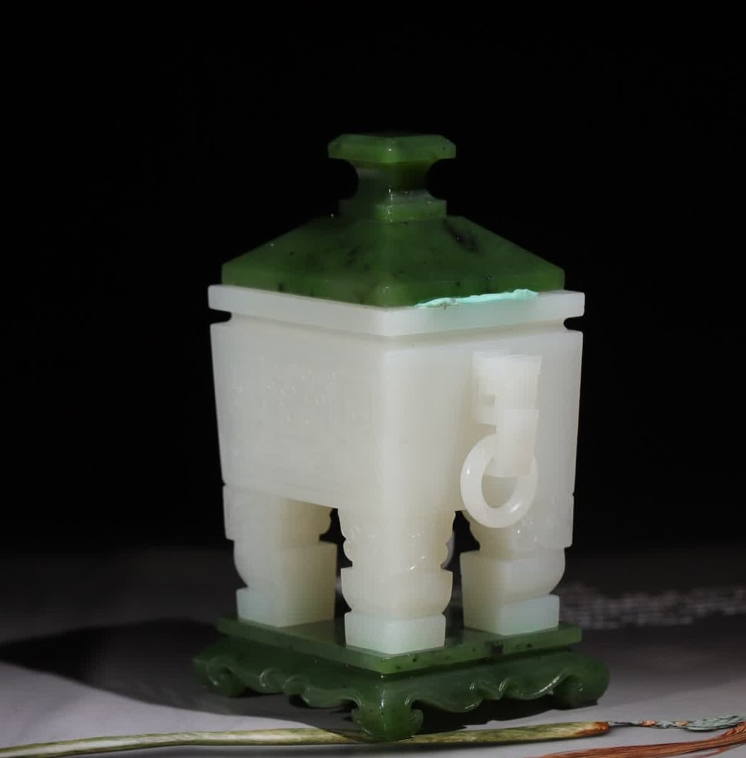 A Qing Dynasty double dragon pattern living ring white jade tripod: Qing Dynasty double dragon pattern live ring white jade tripod This tripod is carved from Hetian white jade, the jade is white as fat, smooth and transparent, and the phosgene is mellow. The shape of