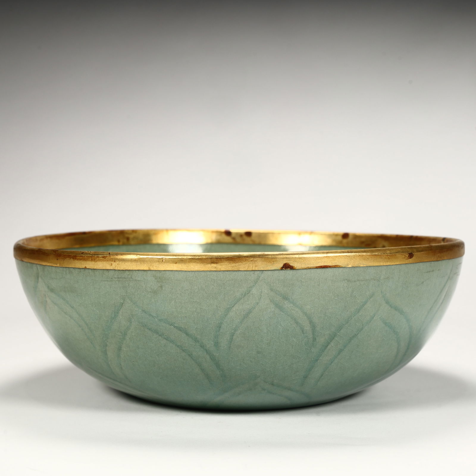 A Song Dynasty celadon carved lotus pattern gilt bowl (1 of 10)