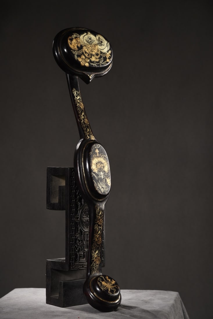 An Exquisite Black Lacquer Painted Gold Bats and Peach Pattern Flower Pattern Ruyi Ornament: An Exquisite Black Lacquer Painted Gold Bats and Peach Pattern Flower Pattern Ruyi Ornament Qing Dynasty, China Size:48cmx12cmx7cm Weight:270g (The Dimensions Of All Batches Are Manually Measured.If Y