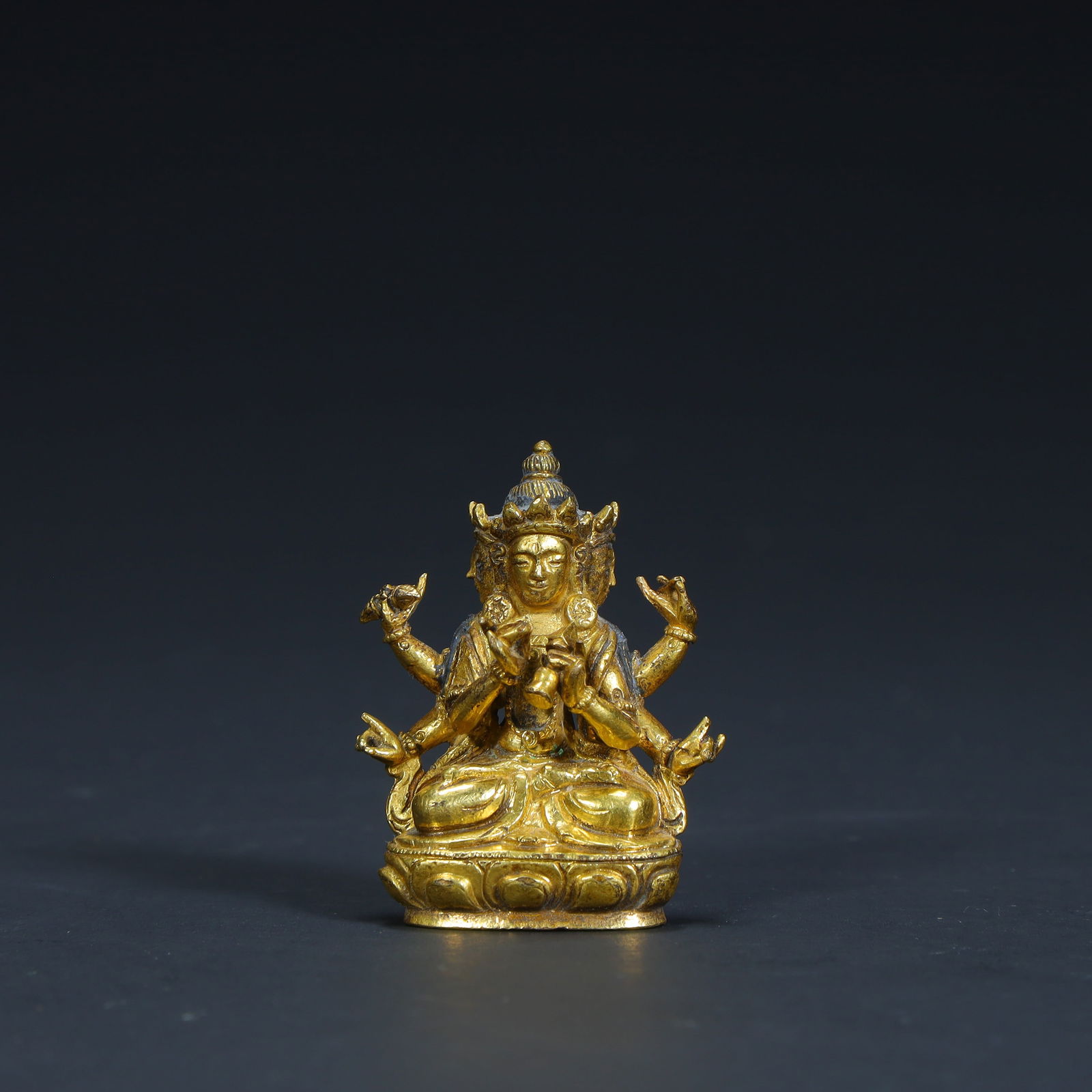 A seated statue of the Buddha Mother with three faces and six arms in copper gilt from the Qing: The bronze gilt three-sided and six-armed seated statue of the Buddha Mother in the Qing Dynasty Size:H:3.8cmL: 3cmW:1.5cmW:28.8g (The Dimensions Of All Batches Are Manually Measured.If You Need More