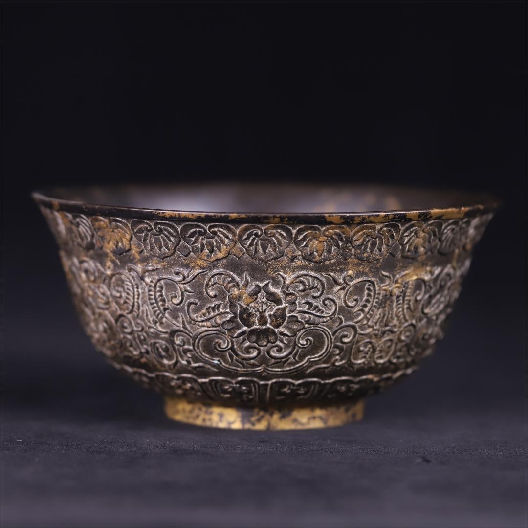 A copper-gilt entwined floral pattern bowl made in the Qianlong period of the Qing Dynasty: The copper gilt entwined floral pattern bowl made in the Qianlong period of the Qing Dynasty is made of the classic shape of open mouth, arc belly, and circle feet, and is made of copper tire gilt tec