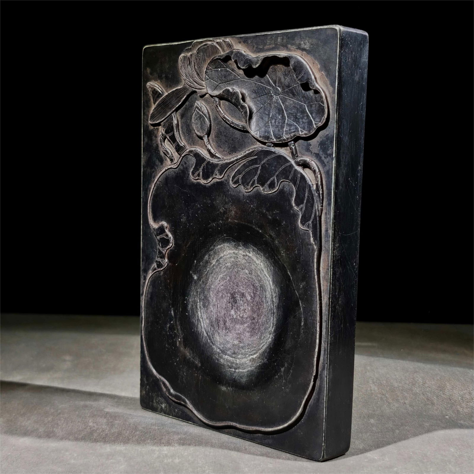 A Qiyang stone inkstone by Zheng Xiaoxu: Zheng Xiaoxu's Qiyang stone inkstone, the surface of the inkstone is embossed with lotus leaves, the natural stone color is red and green, the texture is delicate, the feel is fine and smooth, the ink