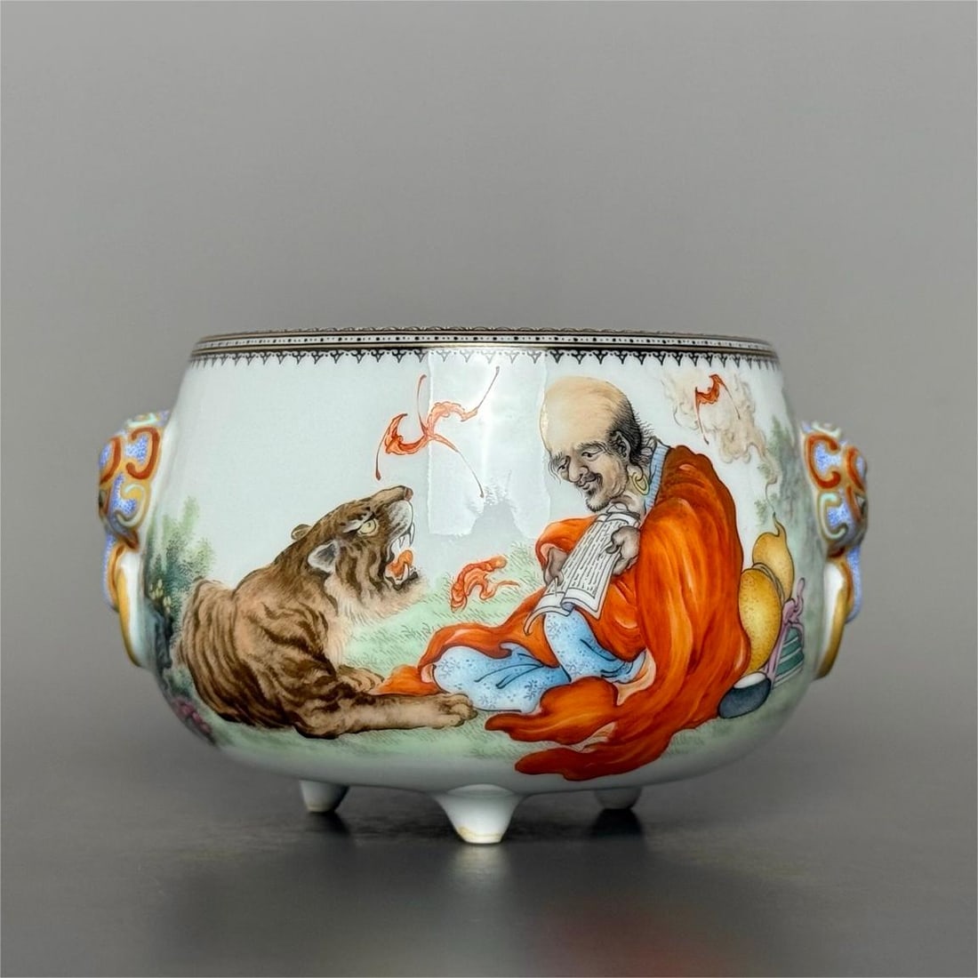 A three-legged incense burner made in the Qianlong period of the Qing Dynasty with a pattern of ink: Qing Dynasty Qianlong year ink color gold-painted pattern edge Fuhu Arhat gilded beast earring three-legged incense burner Fuhu Arhat Maitreya Venerable Size:Calibre:7.1cmH:6cmBellydiameter:9.5cmBotto