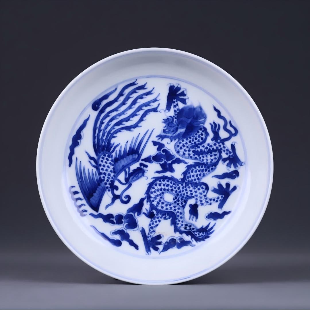 A blue and white dragon and phoenix pattern plate of the Qing Dynasty "Qing Guangxu Year": The Qing Dynasty "Great Qing Guangxu Year" blue and white dragon and phoenix pattern plate has a regular shape, the glazed surface is glossy, the center of the plate is finely painted, the dragon and
