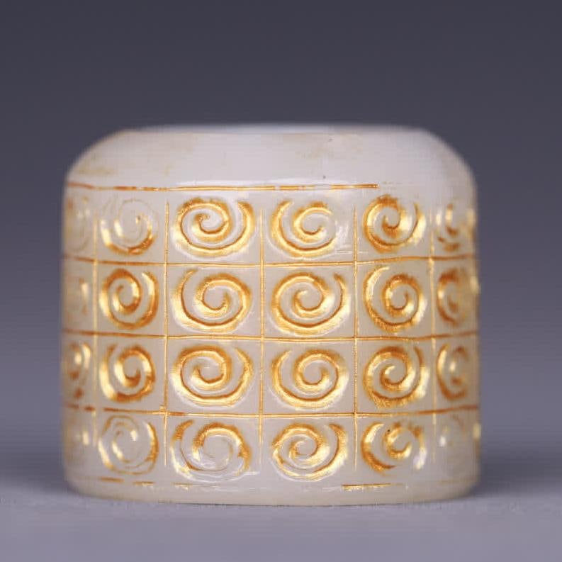 A piece of Hetian jade hook cloud pattern gold finger: Hetian jade hook cloud pattern gold finger The overall material is made of warm Hetian jade, the texture is delicate and oily, the pulp is mellow and natural, the outer wall of the finger is decorated