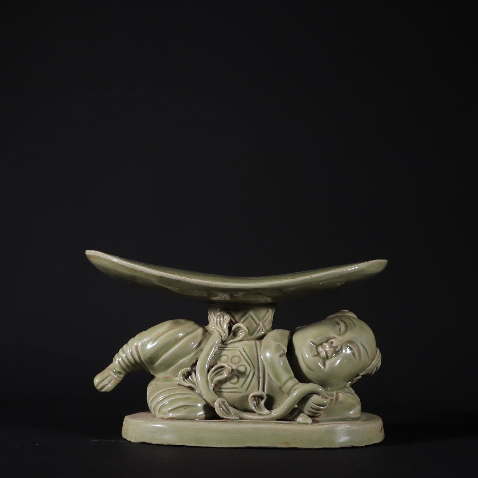 A Tang Dynasty Yue kiln secret color celadon doll pillow: Tang Dynasty Yue kiln secret color celadon doll pillow SIZE: H:12cm W:20.3cm (The Dimensions Of All Batches Are Manually Measured.If You Need More Detailed Information, Please Contact Our Customer Ser