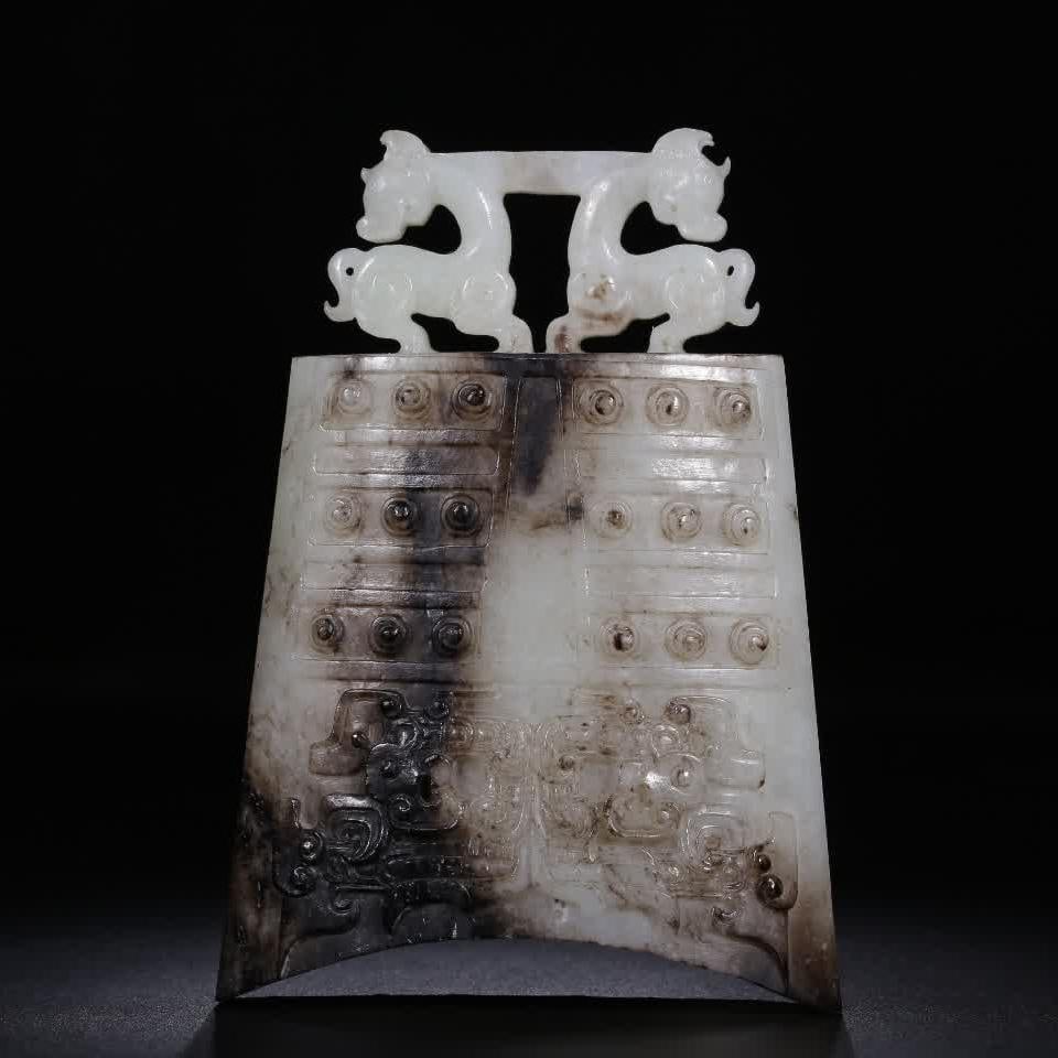A pre-Ming Dynasty Hetian white jade with Qin Shuanglu button bell: The button bell is made of Hetian white jade, with black sand all over the body, jade crystal crystal, warm and elegant tile-shaped bell body, carved double deer-shaped buttons on the top, carved drum