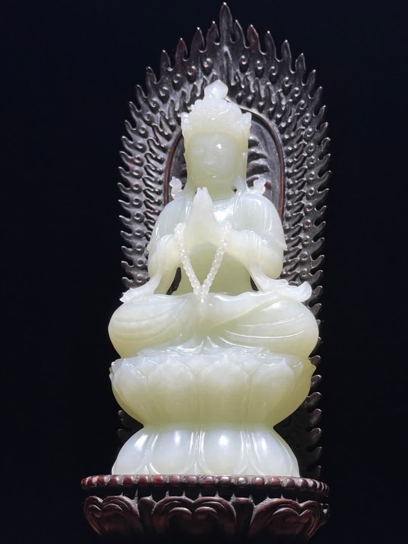 A Qing Dynasty Hetian jade gassho Guanyin seated statue ornament: Qing Dynasty Hetian jade box palm Guanyin seated statue ornament taken from Hetian jade carved Guanyin knot sitting on a double-layer inverted rosette with both hands on the chest holding a string of
