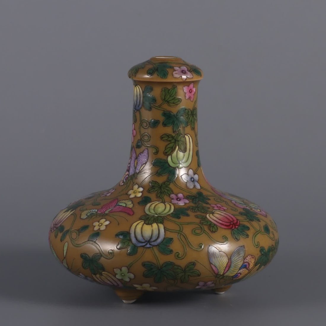 A Qing Dynasty Qianlong year beige glaze plus pastel melon butterfly mianmian three-legged mustard: Qing Dynasty Qianlong year beige glaze plus pastel melon butterfly three-legged mustard bottle SIZE: H: 9.8cm Belly diameter 8.5cm MouthD: 2.8cm (The Dimensions Of All Batches Are Manually Measured.If