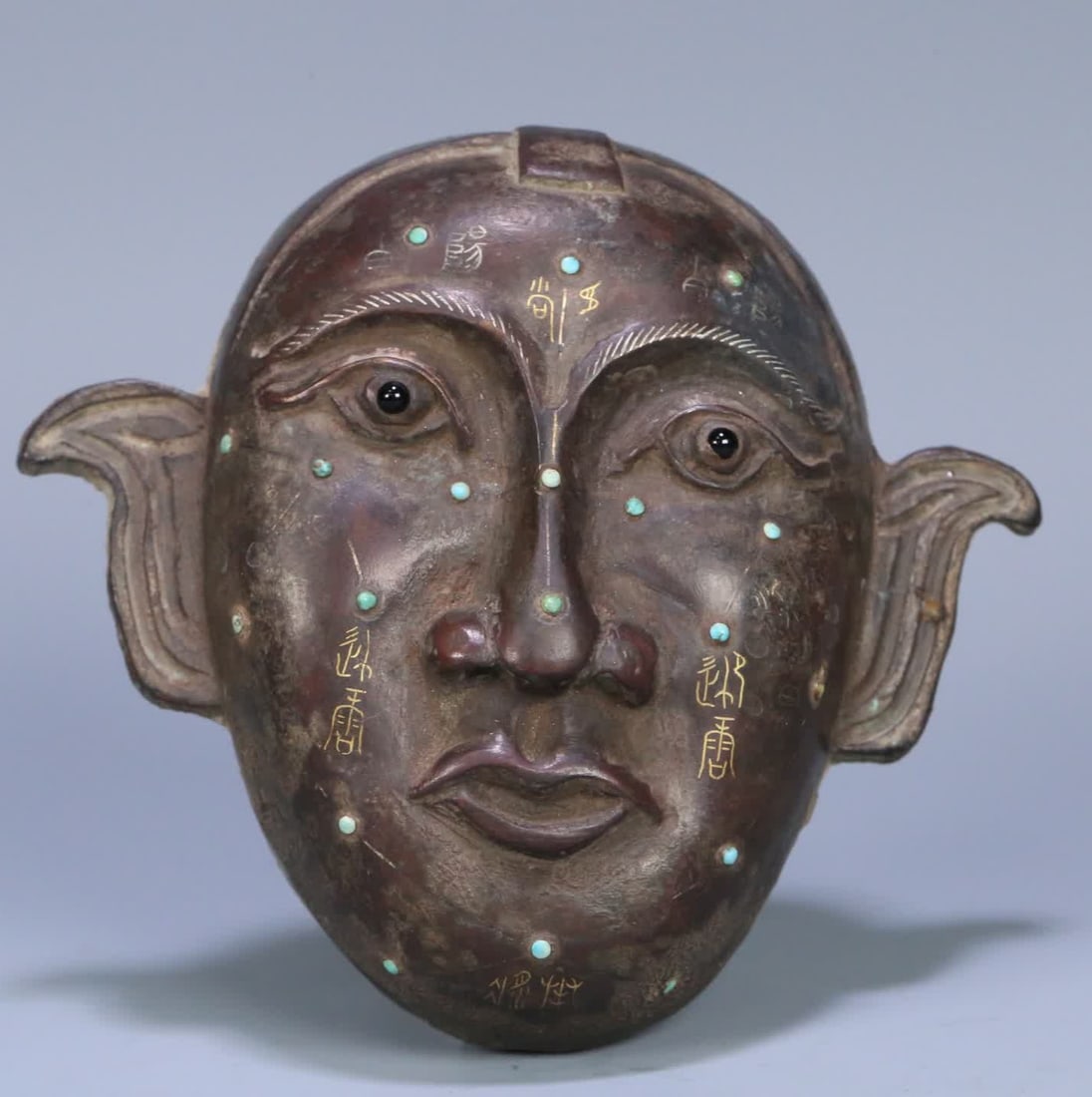 A Han Dynasty Cuojin and silver inlaid turquoise acupuncture mask: Han Dynasty Cuojinyin inlaid turquoise acupuncture human face mask SIZE: 11.2x12.3x4cm W:217.5g (The Dimensions Of All Batches Are Manually Measured.If You Need More Detailed Information, Please Conta