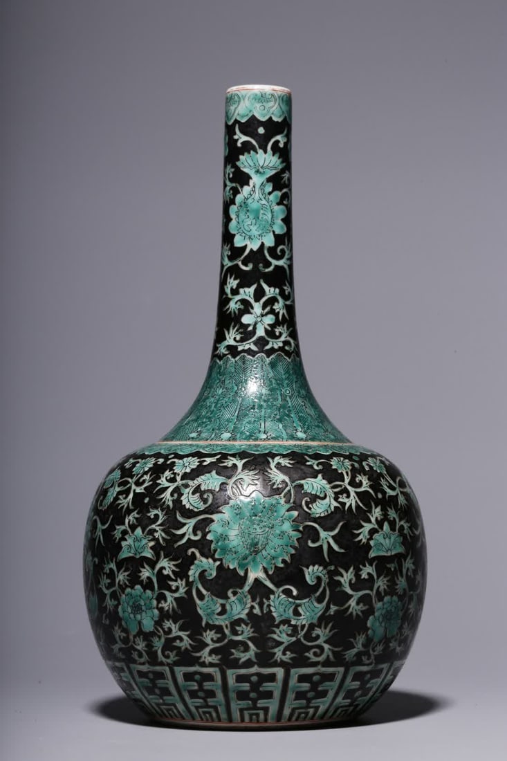 A Qing Dynasty ink green intertwined flower pattern long neck bottle: Qing Dynasty ink green color entwined floral pattern long neck bottle This bottle is small and extravagant, slender neck, shaved shoulders, gradually thickened below the shoulders, and plump lower abd
