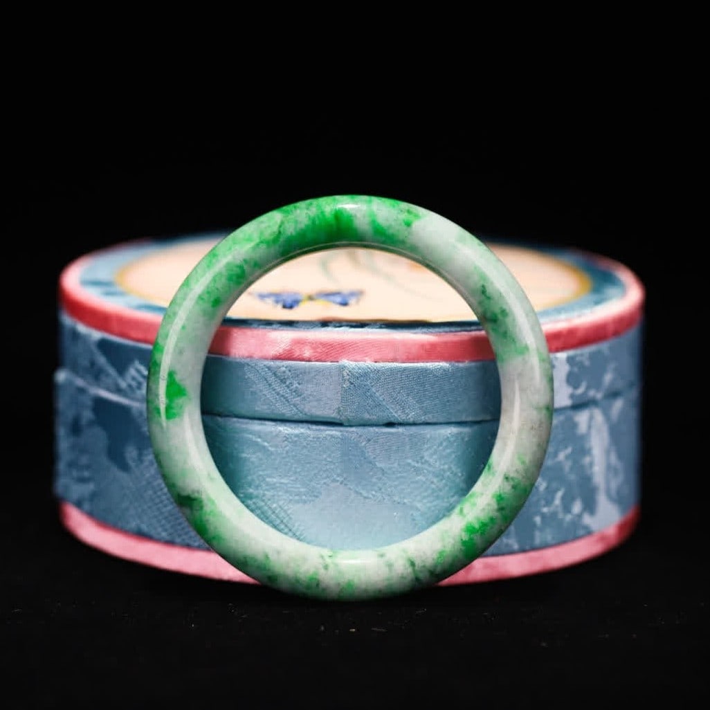 A jade bracelet from the Qing Dynasty: Qing Dynasty jade bracelet is made of old jadeite, the surface is smeared with Zhengyang green flowers, and the color root is clear and natural, showing the mellow texture of old jadeite. Adopting the