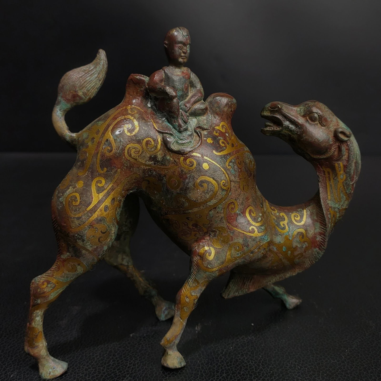 A bronze figurine of a Han Dynasty Cuo Jinyin Hu people riding a camel: In the Han Dynasty, gold and silver were used by Hu people riding camels and bronze figurines SIZE: L:16cm W:5cm H:15cm W:0.9kg (The Dimensions Of All Batches Are Manually Measured.If You Need More De