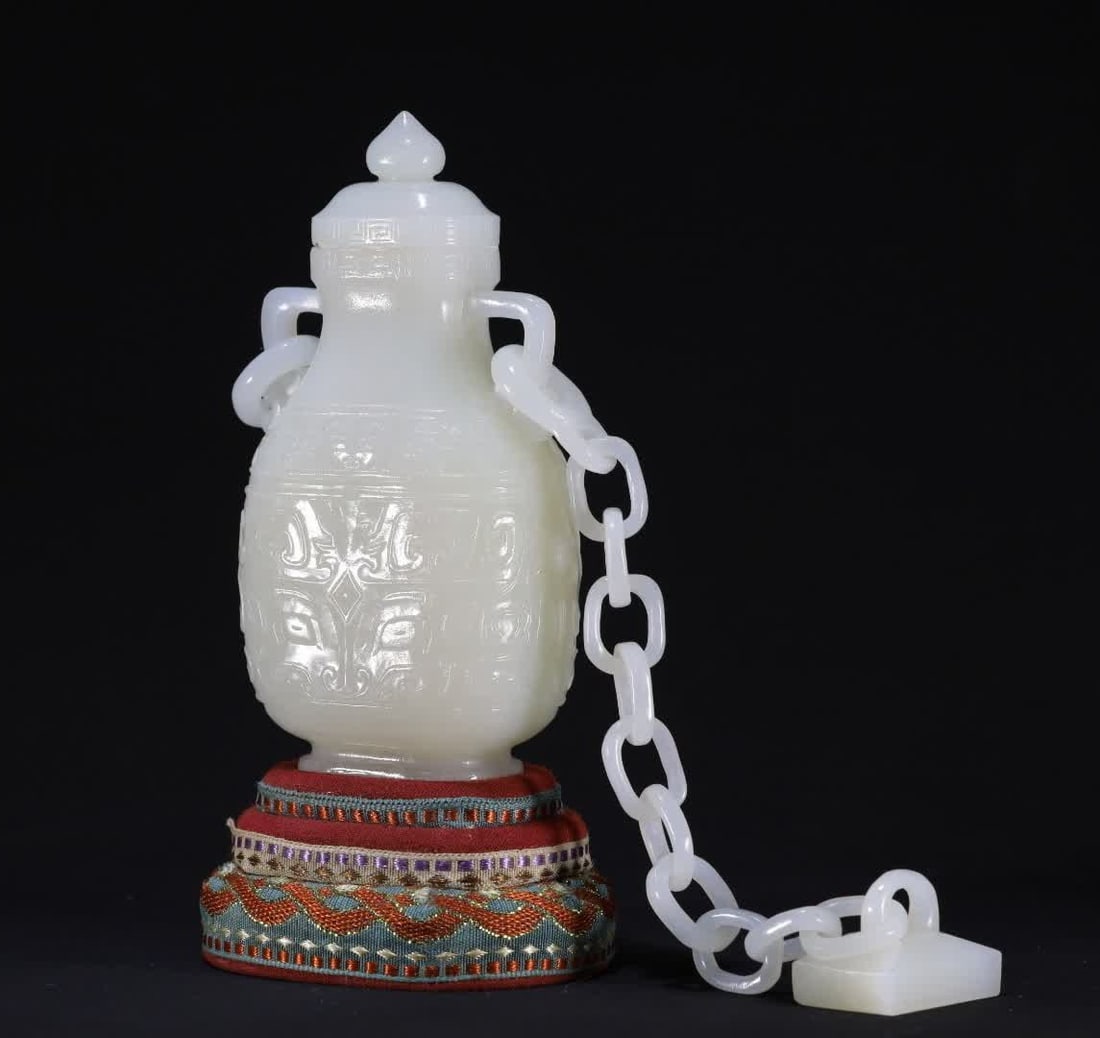 A Qing Dynasty animal face pattern lid bottle ornament: Qing Dynasty animal face pattern cap bottle ornaments are carved from Hetian white jade, the bottle body, live ring, chain, and seal button are carved from the same piece of jade material, the chain i