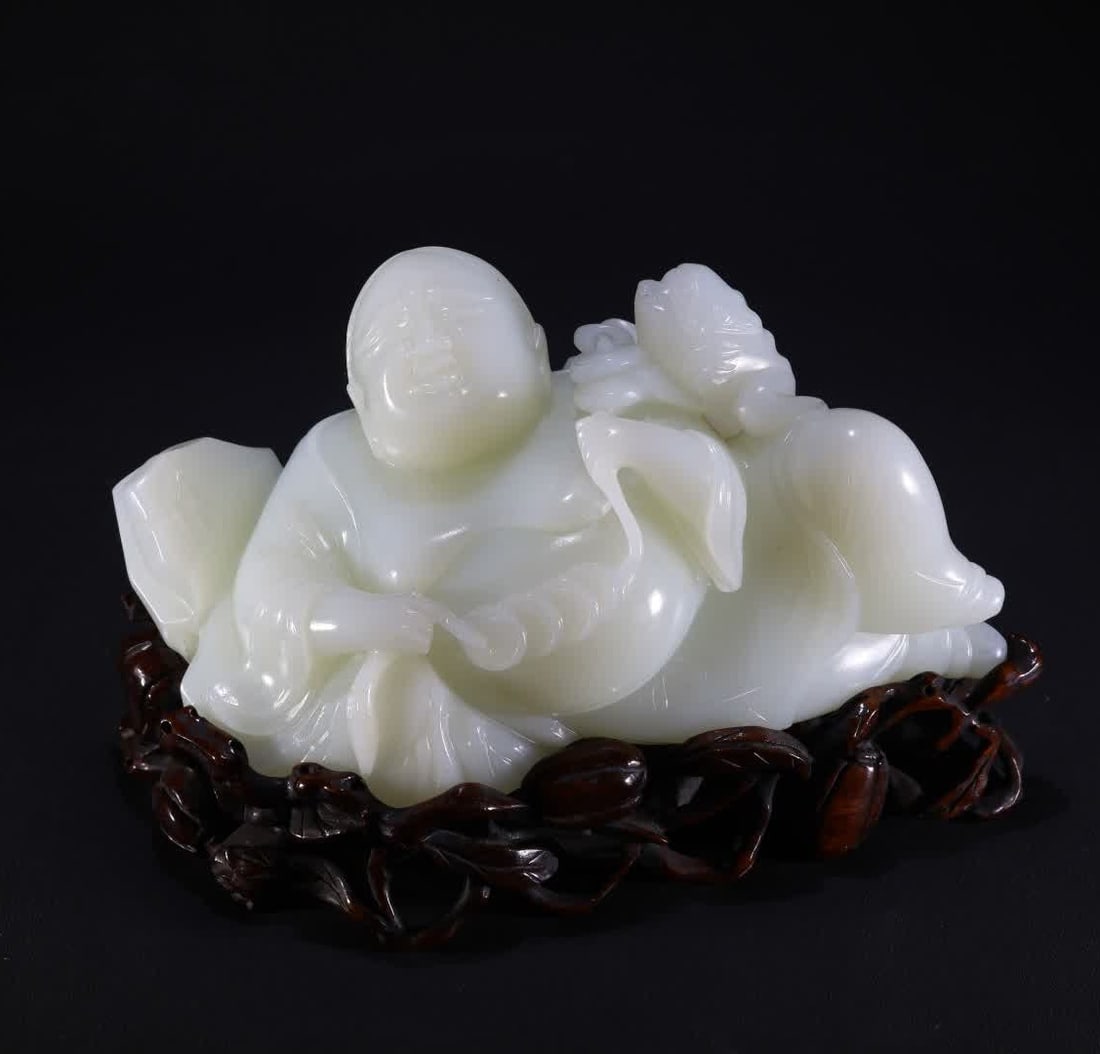 A Qing Dynasty white jade bangs play golden toad ornament: Qing Dynasty white jade bangs play golden toad ornament is carved from Hetian white jade, the bangs are in a semi-reclining posture, the chest is exposed, the smile is full, the face is round and full