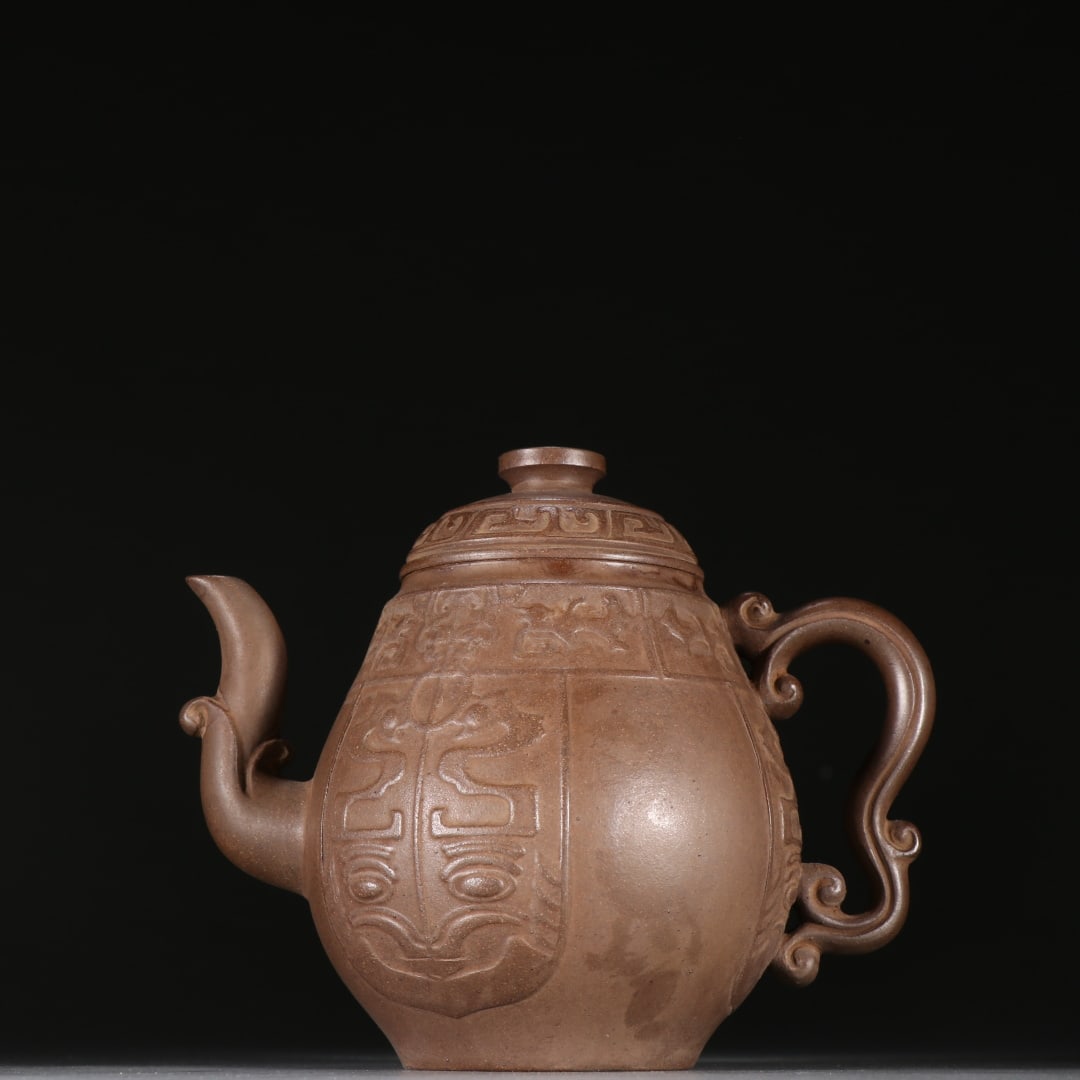 An Exquisite Purple Sands Beast-Face Pattern Teapot: An Exquisite Purple Sands Beast-Face Pattern Teapot Qing Dynasty, China Size:12cmx14.5cm (The Dimensions Of All Batches Are Manually Measured.If You Need More Detailed Information, Please Contact Our 