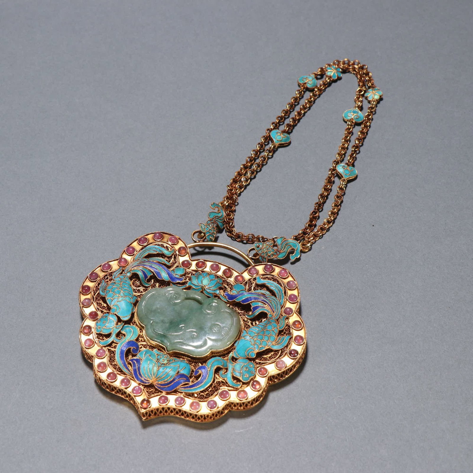 A Qing Dynasty silver-gilt cloisonne inlaid jade-dotted emerald Ganoderma lucidum pendant for more: Qing Dynasty silver gilt cloisonne inlaid jadeite dotted emerald Ganoderma lucidum pendant for more than a year SIZE: Chain L: 60.2cm W: 9.6x10.1cm W: 138.4g (The Dimensions Of All Batches Are Manuall