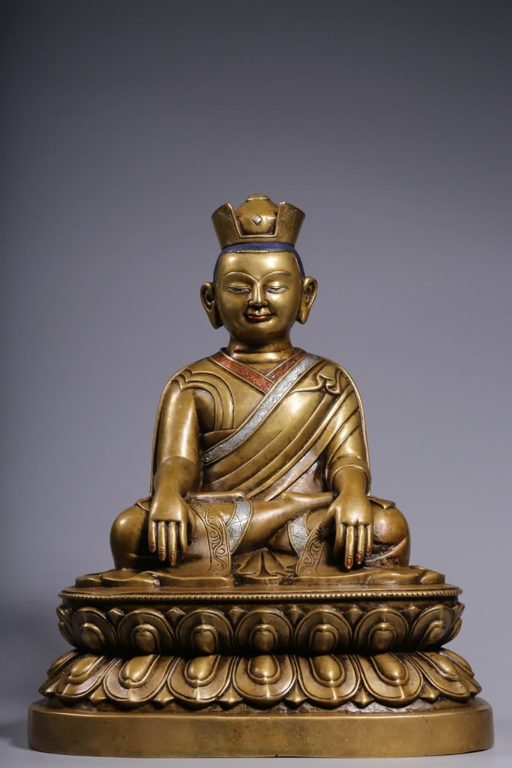 A seated statue of the Qing Dynasty two-color copper and silver Karmapashi: Qing Dynasty two-color bronze and silver Karmapashi seated statue This statue wears a folded hat, a vivid face, a solemn demeanor, hands are sealed, dressed in a vestment, and sits on a lotus seat wit