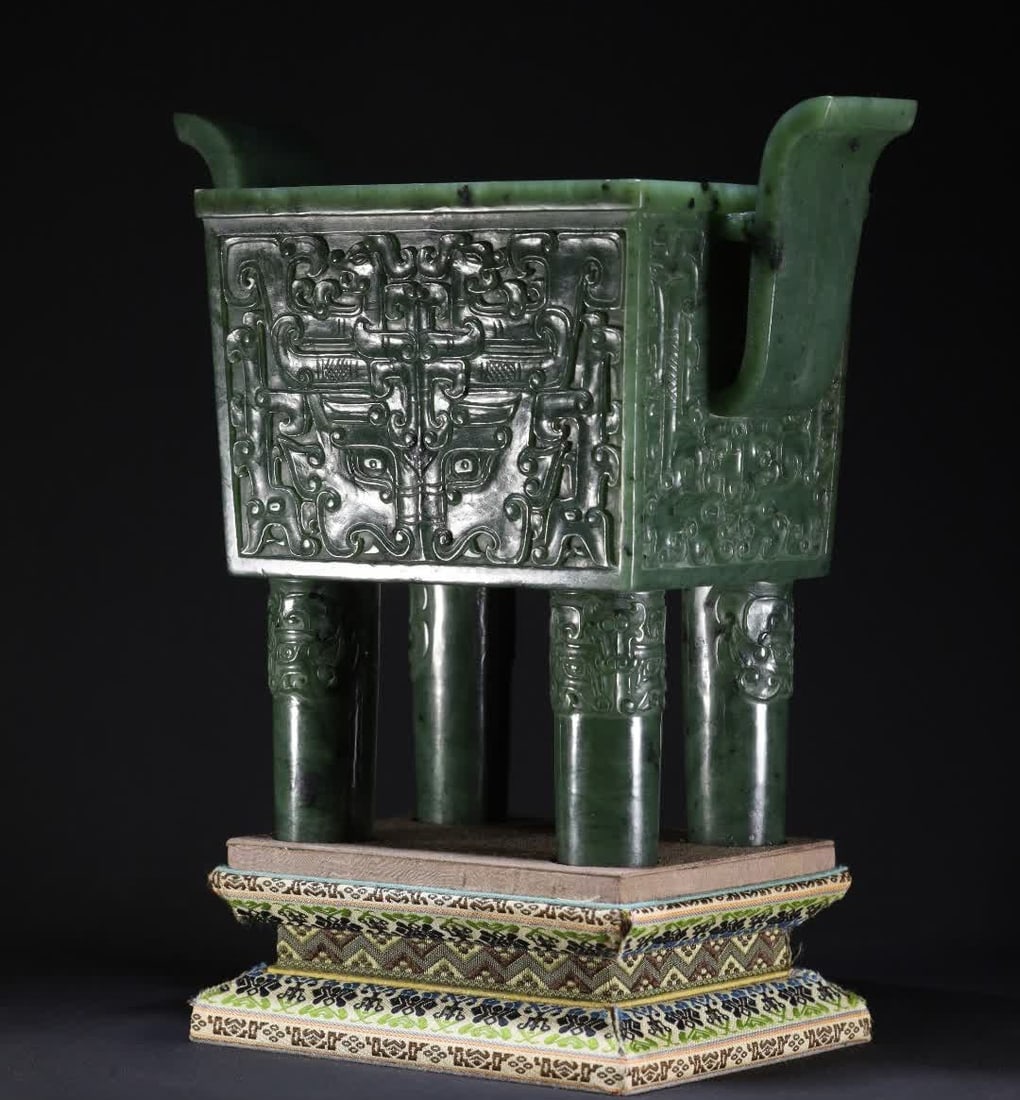 A Qing Dynasty jade beast face tattooed halberd square tripod ornament: The Qing Dynasty jade beast face pattern is carved from Hetian jasper, and the abdominal wall of the vessel is consecrated on all sides with bas-relief animal face patterns, with symmetrical and rigor