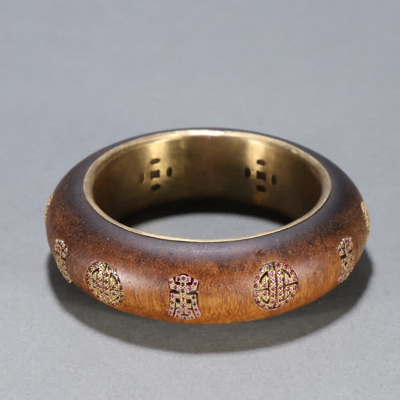 A Qing Dynasty agarwood inlaid silver gilt group longevity pattern bracelet: Qing Dynasty agarwood inlaid silver gilt round longevity pattern bracelet SIZE: Inner diameter 5.9cm W:2.2cm W:72.7g (The Dimensions Of All Batches Are Manually Measured.If You Need More Detailed Info