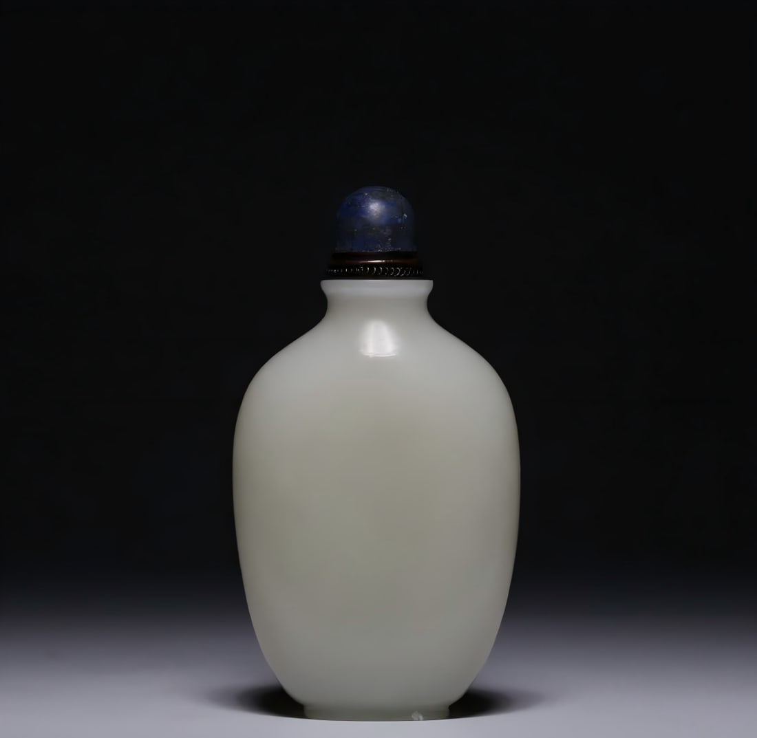 A Qing Dynasty Hetian white jade snuff bottle: Qing Dynasty Hetian white jade snuff bottle The snuff bottle is made of high-quality Hetian white jade excavated and has a regular shape. The round mouth is straight neck, the body is flat and round, 
