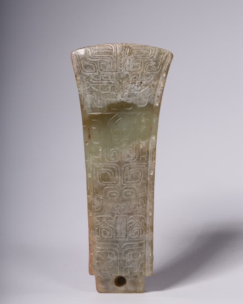 A jade gluttonous pattern axe-shaped pendant of the Han Dynasty: The pendant is carved from Hetian jade, with delicate jade, dense structure, warm texture, oily nature, local band and comfortable tentacles. It is axe-shaped, beautiful in shape, simple and elegant. 