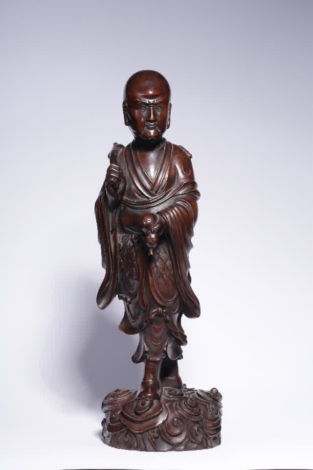 A statue of a boxwood Arhat in the Qing Dynasty: Qing Dynasty boxwood arhat statue This statue is carved from high-quality boxwood wood, carved as a whole, with a dull wood color, delicate wood texture, high density, solid and tough, and soft pulp. 