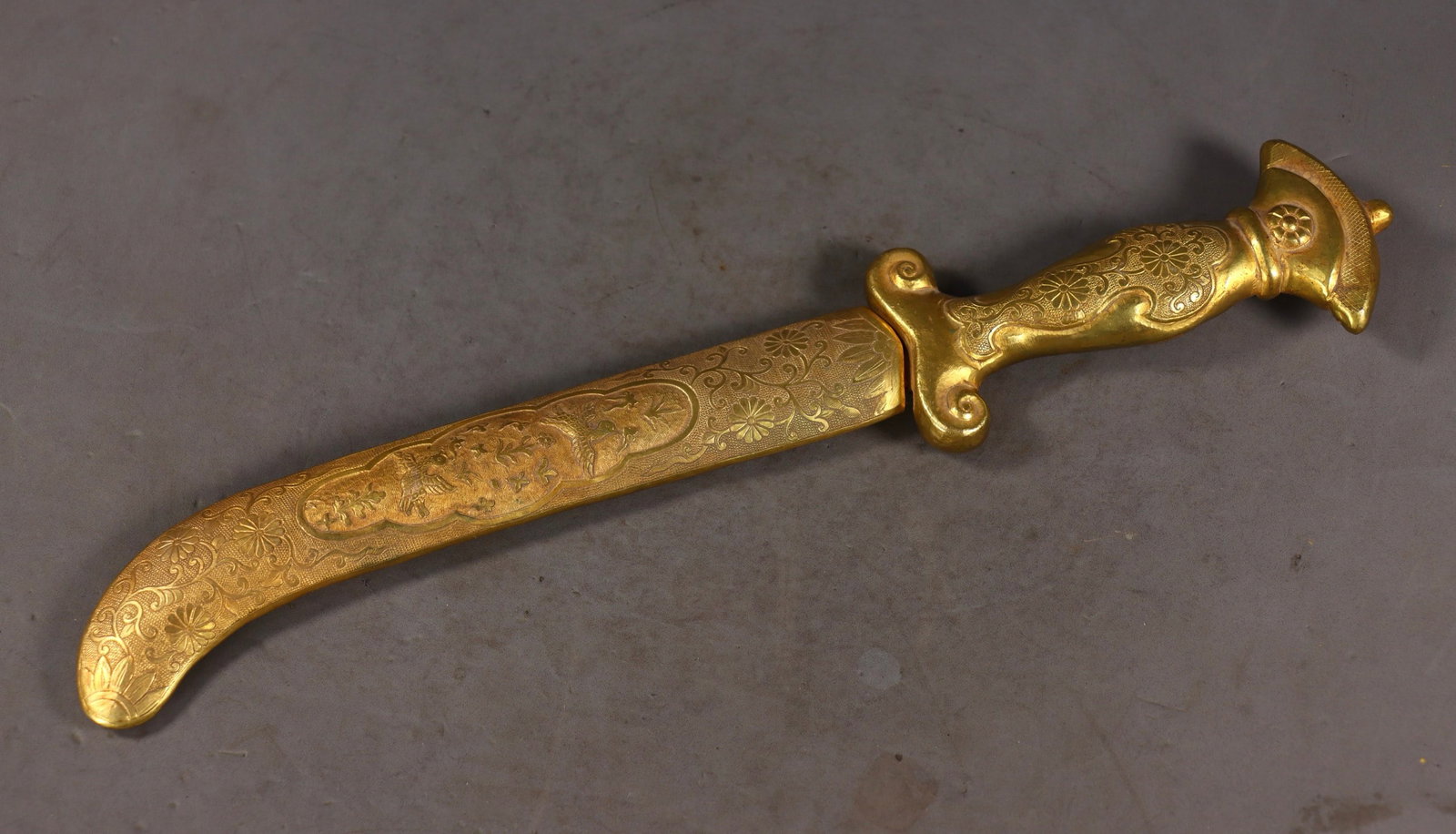 An Exquisite Gilt Bronze Flower and Bird Pattern Sword: An Exquisite Gilt Bronze Flower and Bird Pattern Sword Qing Dynasty, China Size:2.5cmx34cmx6cm Weight:327g (The Dimensions Of All Batches Are Manually Measured.If You Need More Detailed Information, P