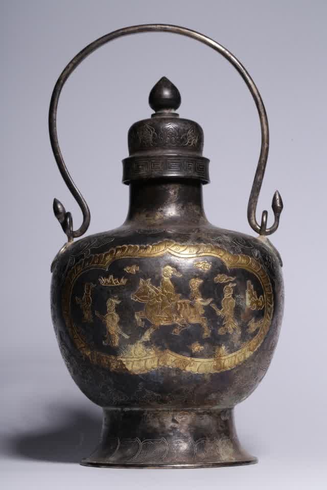 A silver-gilt engraved character story picture in the Tang and Song dynasties of the Tang and Song: Tang and Song dynasties silver-gilt engraved character story picture Tiliang bottle This Tiliang bottle has an open mouth with a lid, a bulging neck, a circle foot at the bottom, and a circle foot out