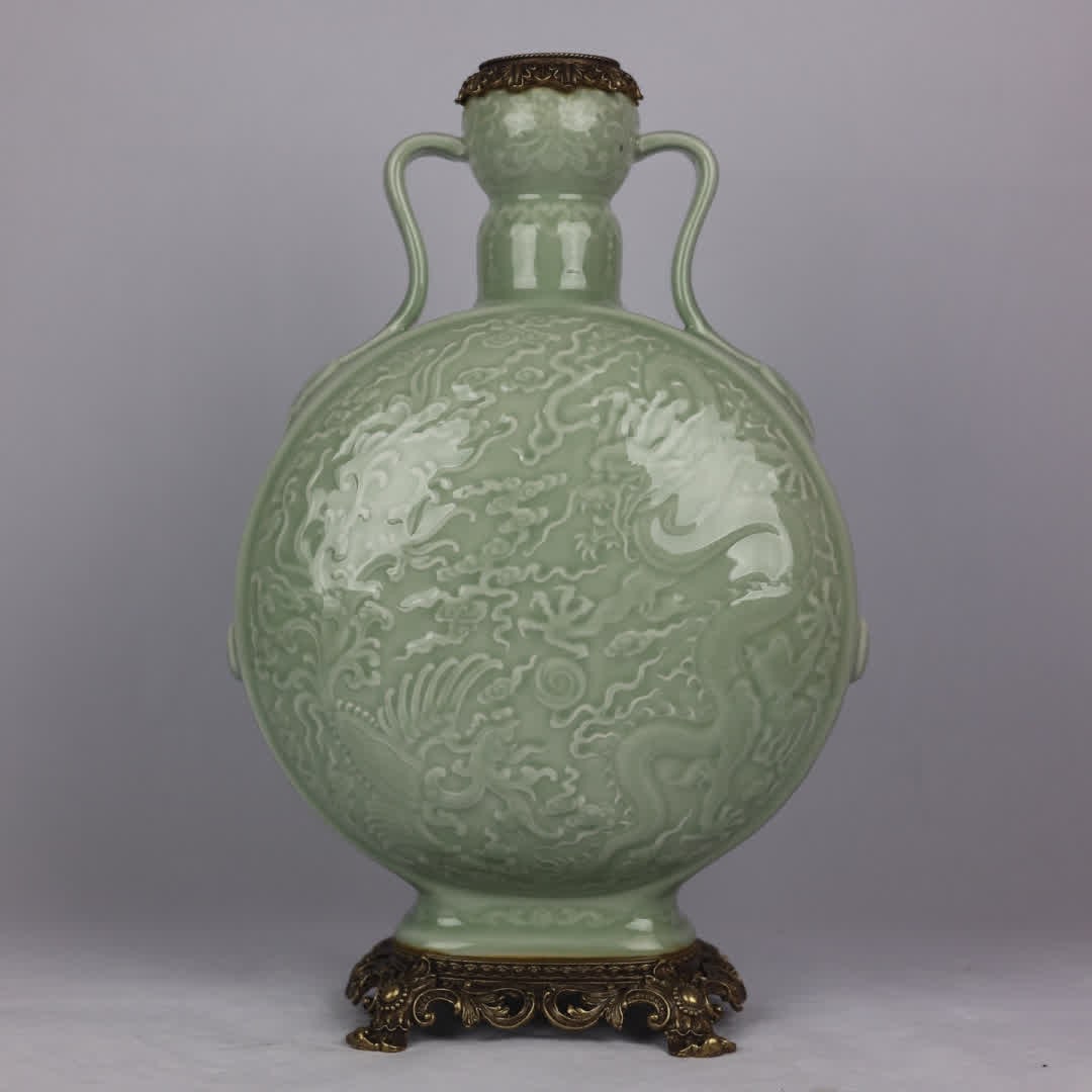 A Qing Dynasty pink blue glaze carved dragon and phoenix pattern inlaid with a bronze moon embrace: Qing Dynasty pink blue glaze carved dragon and phoenix pattern inlaid copper moon vase SIZE: H: 44cm MouthD: 9cm D: 17cm Bottom diameter 18cm (The Dimensions Of All Batches Are Manually Measured.If Yo