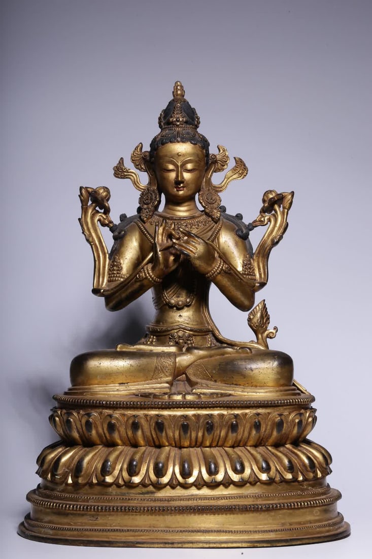 A seated statue of Guanyin holding a lotus in copper gilt in the Qing Dynasty (1 of 9)