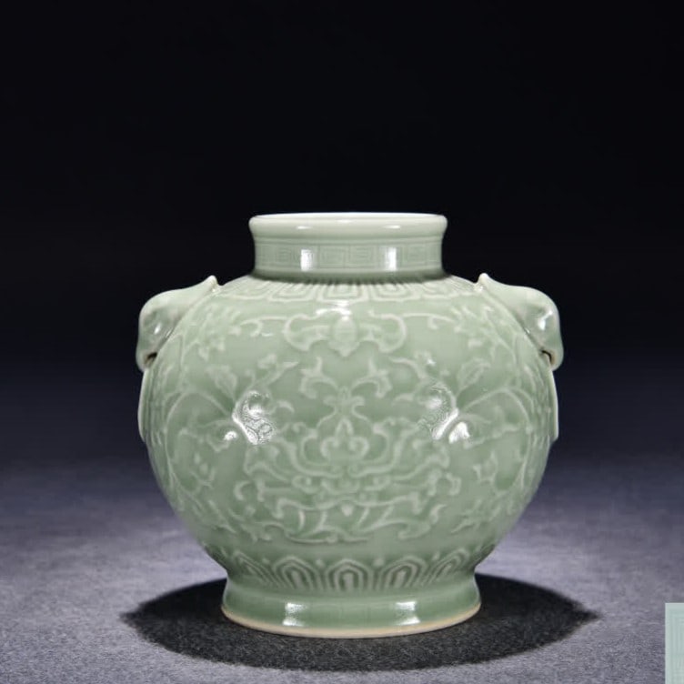 A Qing Dynasty Qianlong celadon carved flower auxiliary head jar (1 of 9)