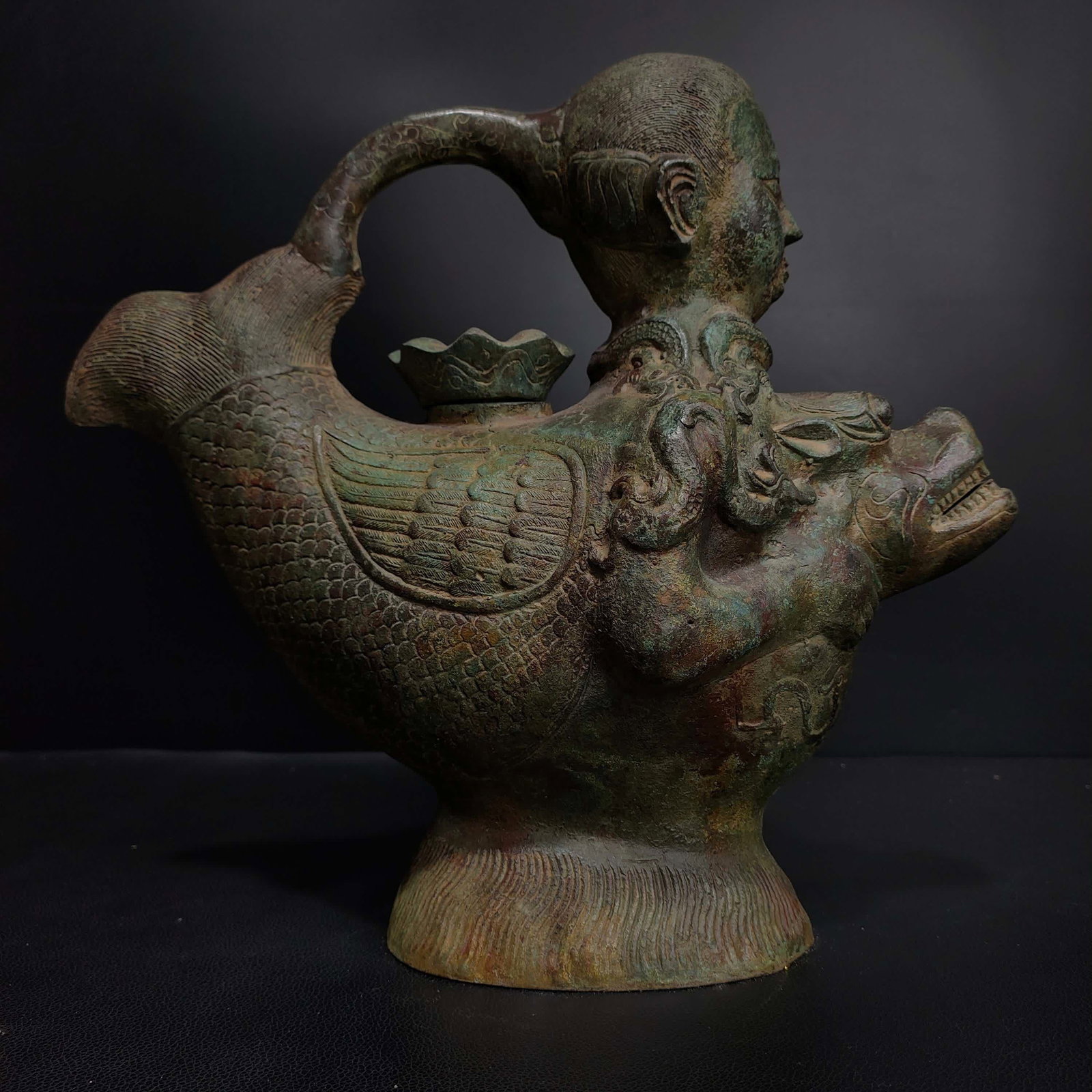 A bronze human head fish body holding a beast bowl (1 of 9)