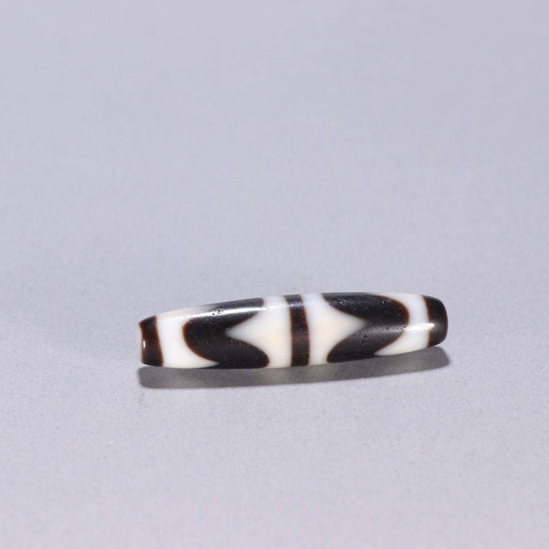 An Exquisite Dzi Bead Ornament: An Exquisite Dzi Bead Ornament Qing Dynasty, China Size:5.4cmx1.2cm Weight:12.7g (The Dimensions Of All Batches Are Manually Measured.If You Need More Detailed Information, Please Contact Our Customer