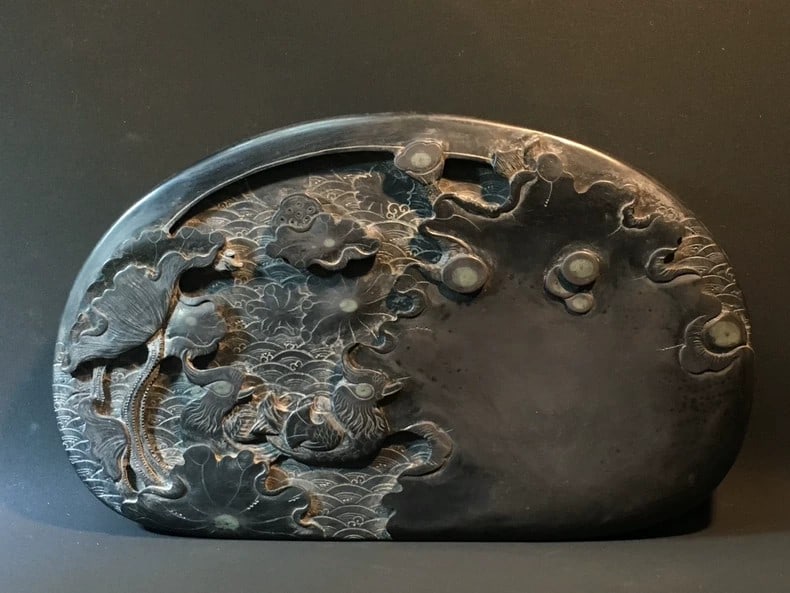 A delicate Qing Dynasty Duan inkstone depicting mandarin ducks playing with lotuses (1 of 9)