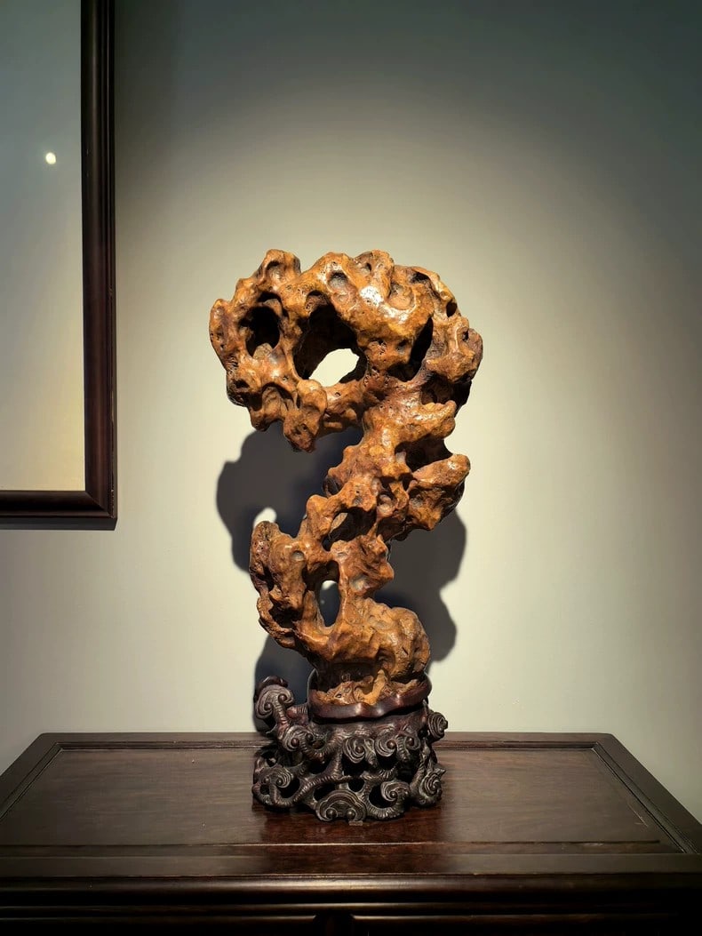 A beautiful Qing Dynasty red Taihu stone with lingzhi-patterned rosewood base: Qing Dynasty Red Taihu stone with lingzhi-patterned rosewood baseSIZE:26x16x56cm(The Dimensions Of All Batches Are Manually Measured.If You Need More Detailed Information, Please Contact Our Customer 
