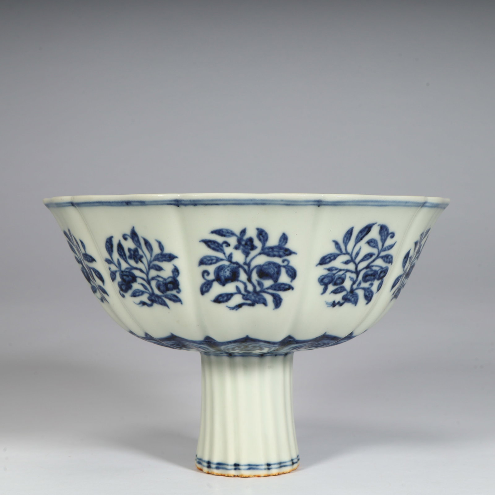 A fine Ming Dynasty Xuande blue-and-white brocade flower-and-fruit pattern tall stem bowl: Ming Dynasty Xuande blue-and-white broken-branch floral and fruit pattern high-footed bowlSIZE:H: 11.5cm L: 17cm W: 17cm W: 414g(The Dimensions Of All Batches Are Manually Measured.If You Need More De