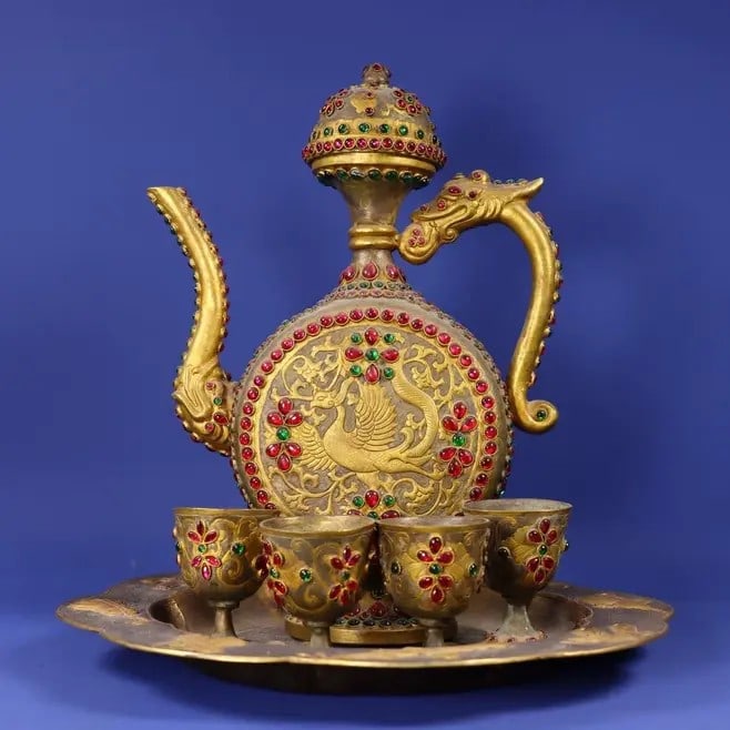 A fine Qing Dynasty wine vessel partially gilded with gemstones inlaid with dragons and phoenixes: Qing Dynasty partial gilded and jeweled dragon and phoenix wine setsSIZE: H: 25cm Tray H: 2cm D: 25cm Wine Pot H: 25cm L: 17cm W: 7cm Wine Glass H: 6cm Spout D: 4.5cm W: 1822g(The Dimensions Of All Ba
