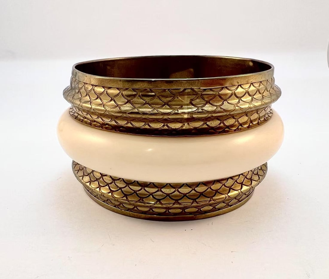 Brass & Faux Ivory Bangle Set - Art Deco Tribal Statement: This stunning vintage bangle set features two intricately engraved brass bangles with a fish-scale pattern, paired with a smooth, cream-colored faux ivory centerpiece. The combination of textures and