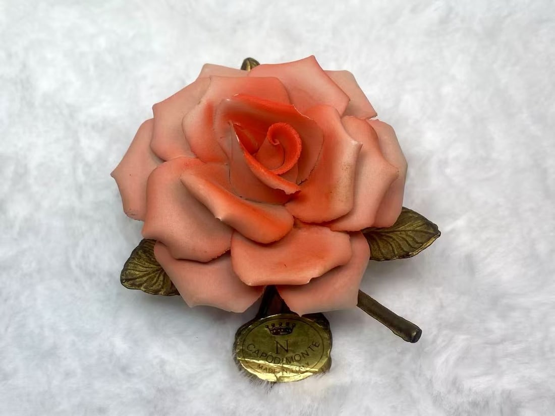 Capodimonte Italian Porcelain Rose with Metal Leaves and Original Label: This exquisite porcelain rose is a fine example of Capodimonte craftsmanship from Naples, Italy. Featuring delicately molded petals and bronze-toned metal leaves, it embodies timeless elegance. The pi