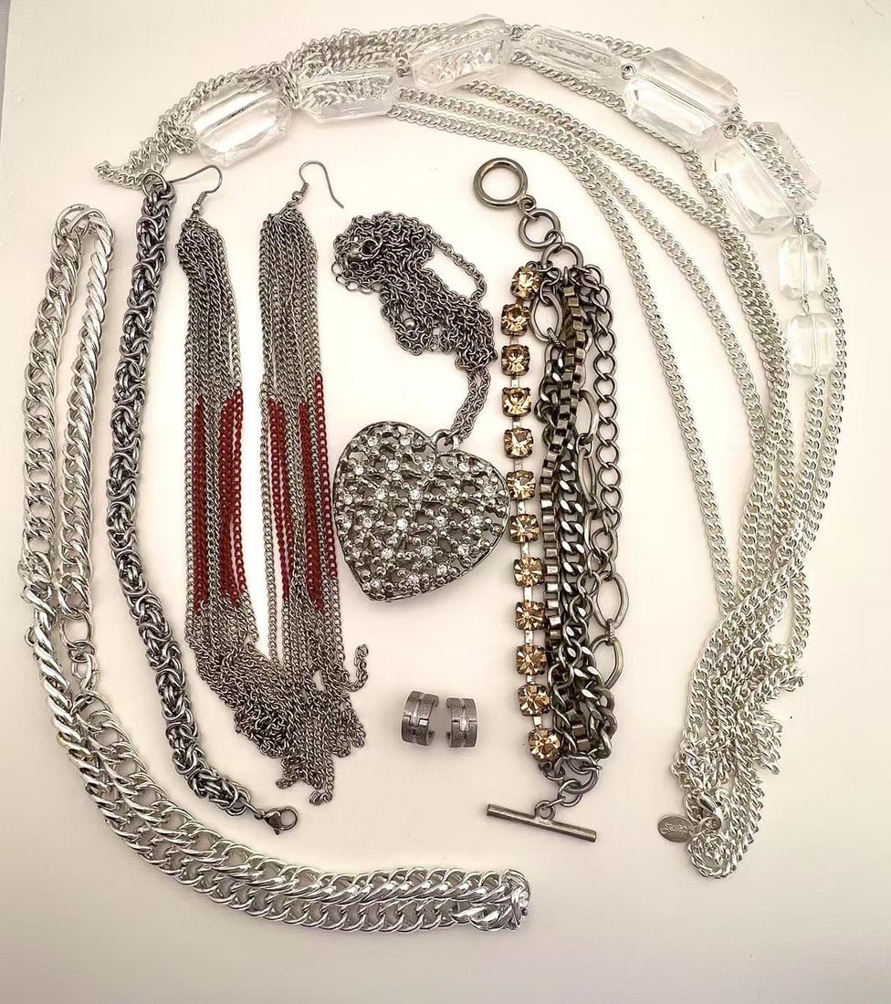 Lot of Mixed Silver-Tone Fashion Jewelry – Necklaces, Bracelets, Earrings: Assortment of silver-tone fashion jewelry including multi-strand chain necklaces, a rhinestone heart pendant necklace, layered chain bracelets, dangle earrings with red and silver chains, a rhinestone