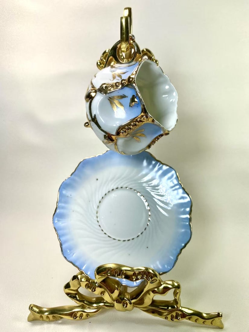 Victorian Style Blue & White Gilded Tea Cup & Saucer Set | Unique Three-Legged Design | Numbered 76: This charming Victorian-style teacup and saucer set features a distinctive three-legged design with an elegant blue and white gradient finish accented by gold leaf motifs. Both the cup and saucer are