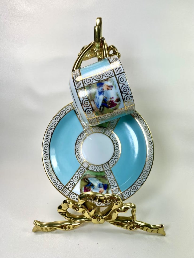 Czechoslovakia Blue Lady Portrait Tea Cup & Saucer Set | 1957 Edition | Crest Mark: This stunning tea cup and saucer set from Czechoslovakia features a light blue base adorned with classic lady portrait panels and intricate gold scrollwork, exuding an elegant European nobility vibe.