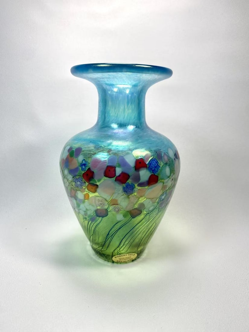 Robert Held Canadian Art Glass Vase | Hand Blown Millefiori Floral Design: Beautiful hand blown art glass vase by Robert Held, featuring vibrant millefiori floral patterns over a green and blue iridescent base. Handmade in Canada, perfect for collectors or display.