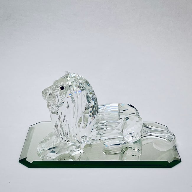 Swarovski SCS Crystal Lion Figurine | With Original Box & Certificate | Base Not Included: This Swarovski SCS (Swarovski Crystal Society) crystal lion figurine symbolizes strength and majesty. Expertly crafted from clear faceted crystal, the lion features intricate details from its flowing 