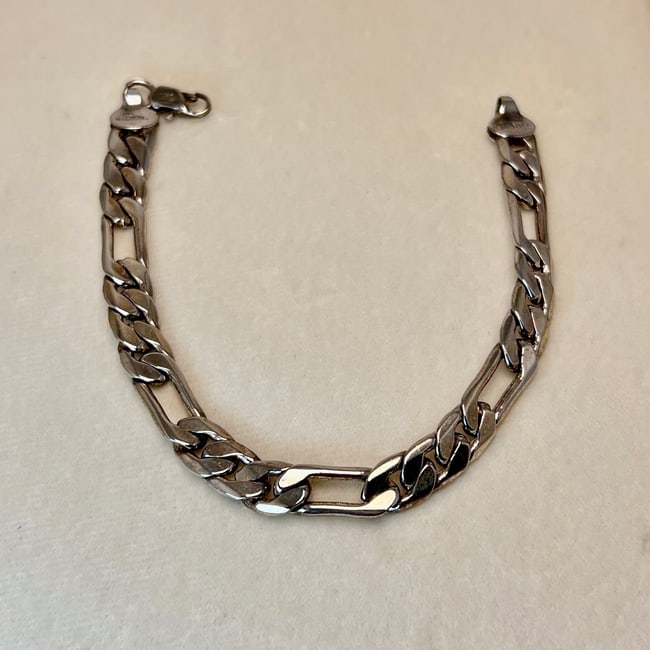 Sterling Silver Men’s Bracelet – 925 Figaro Style: A solid 925 sterling silver men’s bracelet in a classic Figaro-style link design, secured with a lobster clasp. Stamped "925"”STERLING” to indicate sterling silver content. The bracelet 