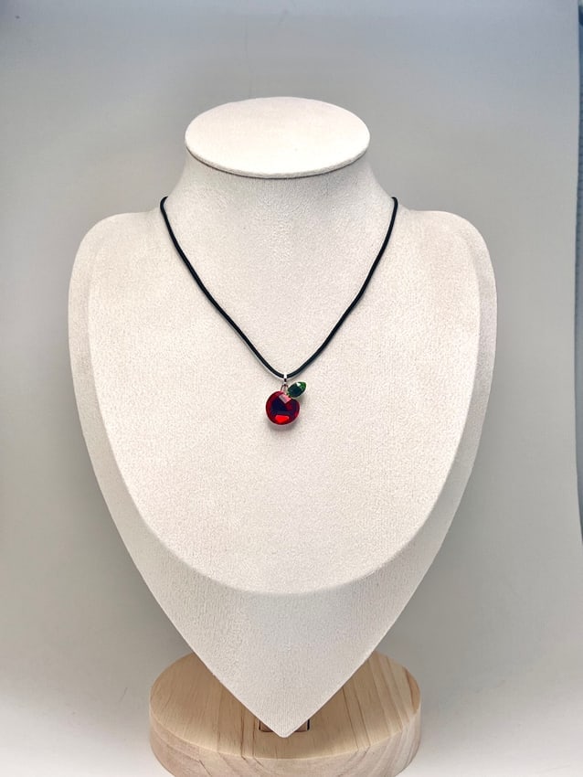 Retro Swarovski Red Crystal Apple Pendant Necklace: Charming retro necklace featuring a glossy red apple-shaped Swarovski crystal pendant on a black cord. The faceted crystal captures light beautifully, giving off a playful yet elegant glow. The pendan